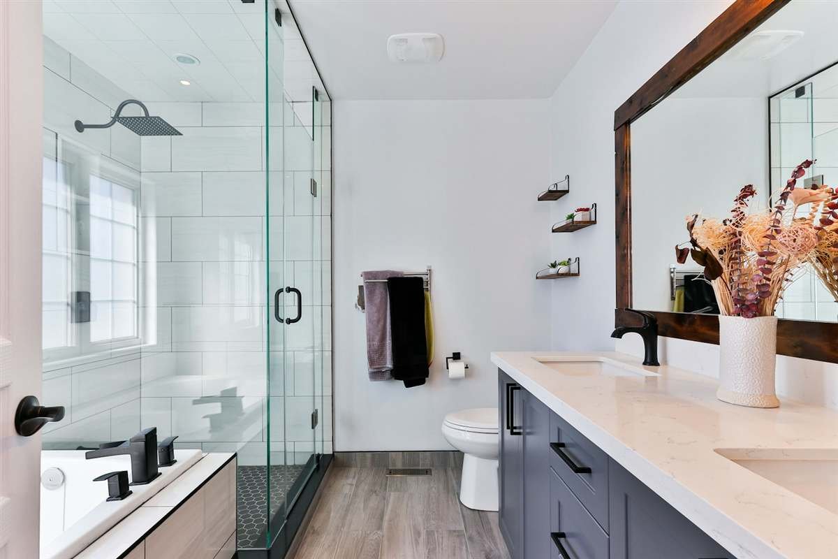 Completed bathroom with glass shower, stone vanity, and tile flooring